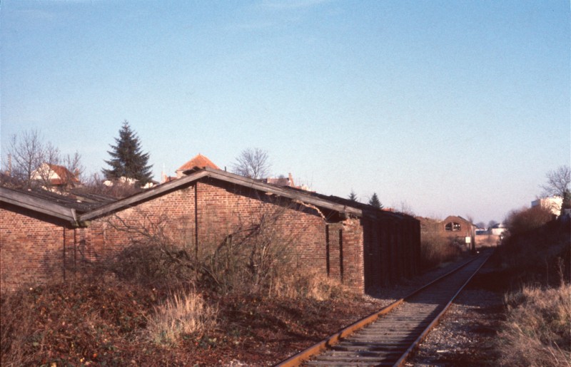 Les dépôts de Rocourt, bâtiment vapeur puis autorail, vus vers la gare SNCF le 8 décembre 1985, avec les poteaux posés par la SNCF fin 1981. Le BV de Rcourt est au fond sur la droite (© Frédéric Duf)